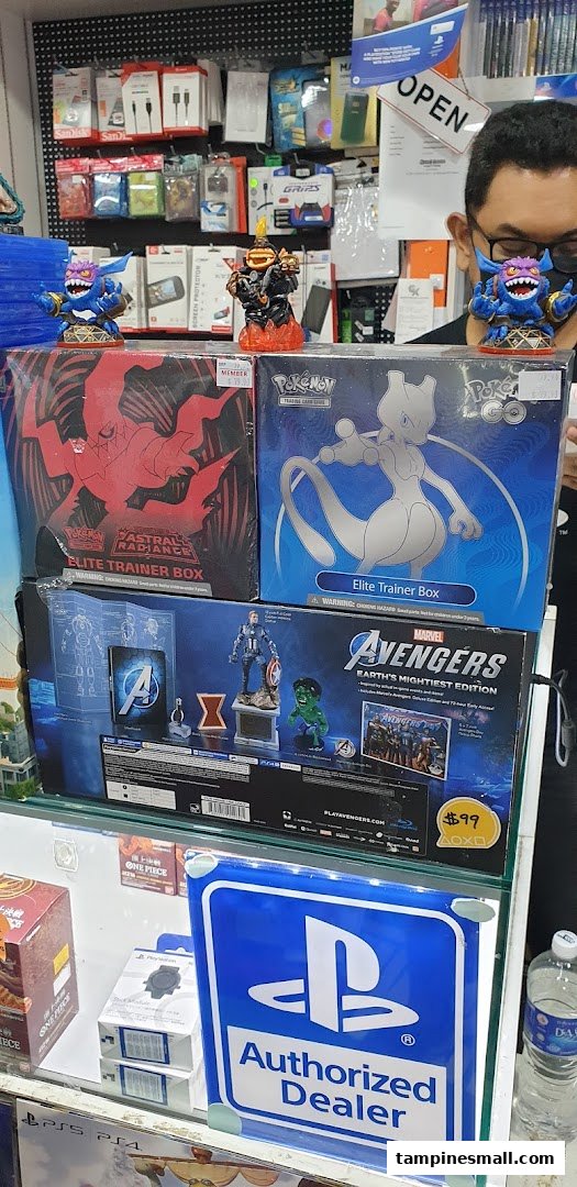 A retail display featuring Pokémon and Marvel merchandise, with a staff member in the background.