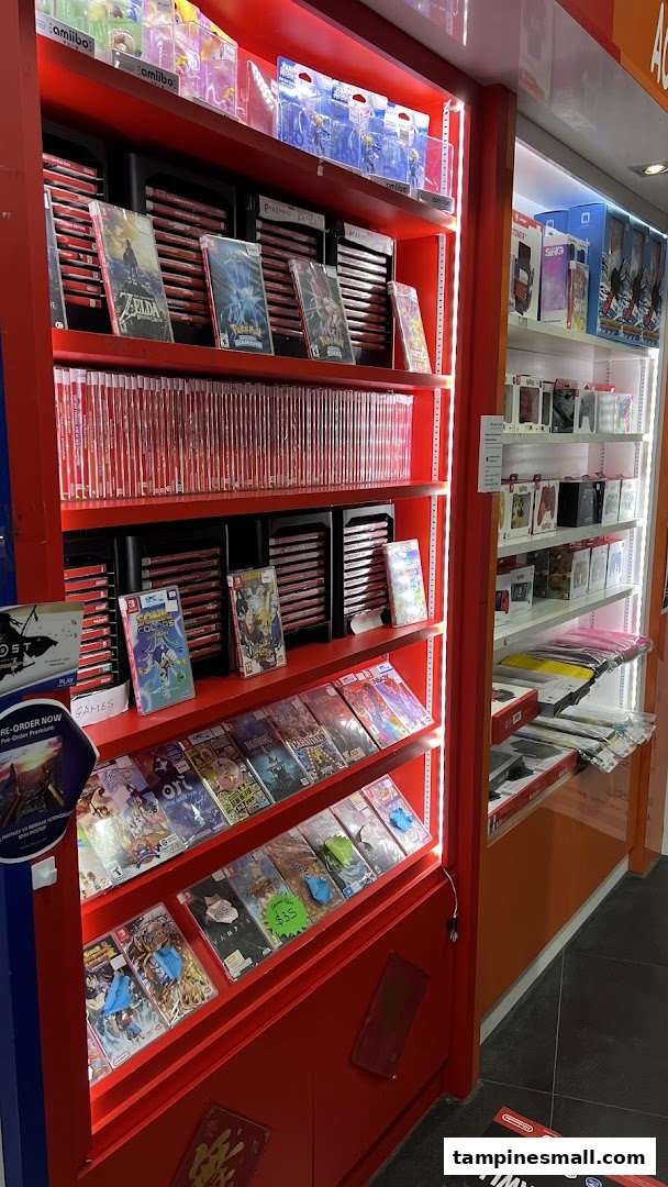 A vibrant display of video games, consoles, and gaming accessories on red shelves.