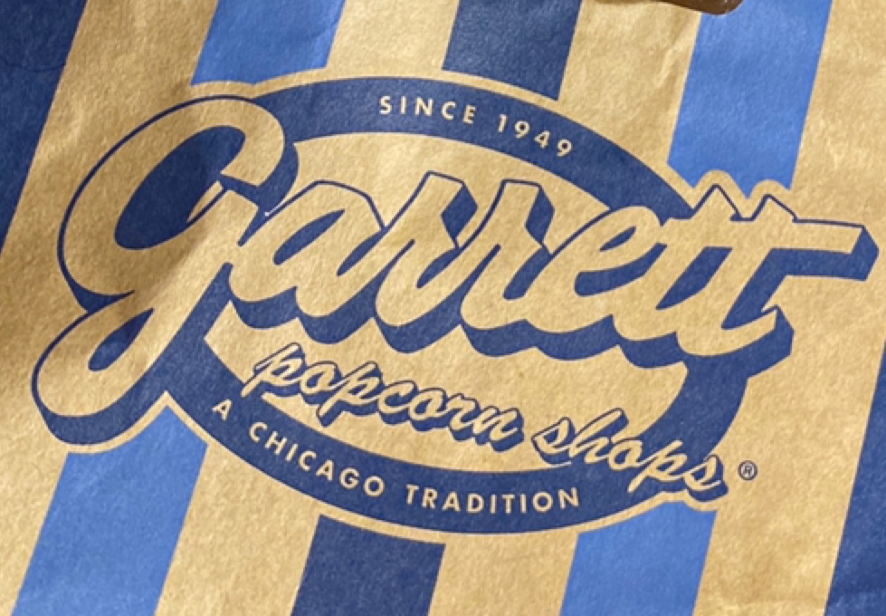 Close-up of the iconic Garrett Popcorn Shops logo on a classic striped bag.