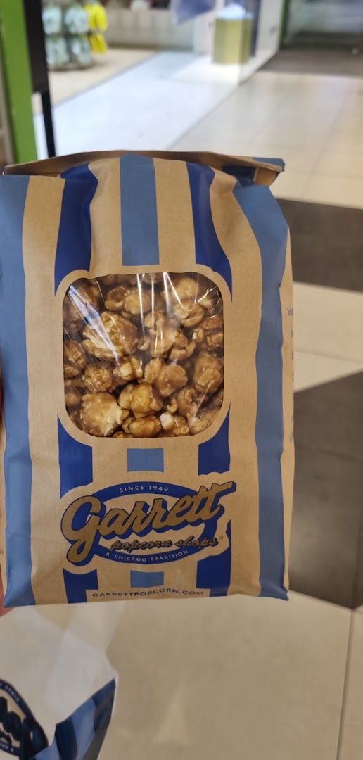 A close-up of a classic Garrett Popcorn Shops bag filled with delicious caramel popcorn.