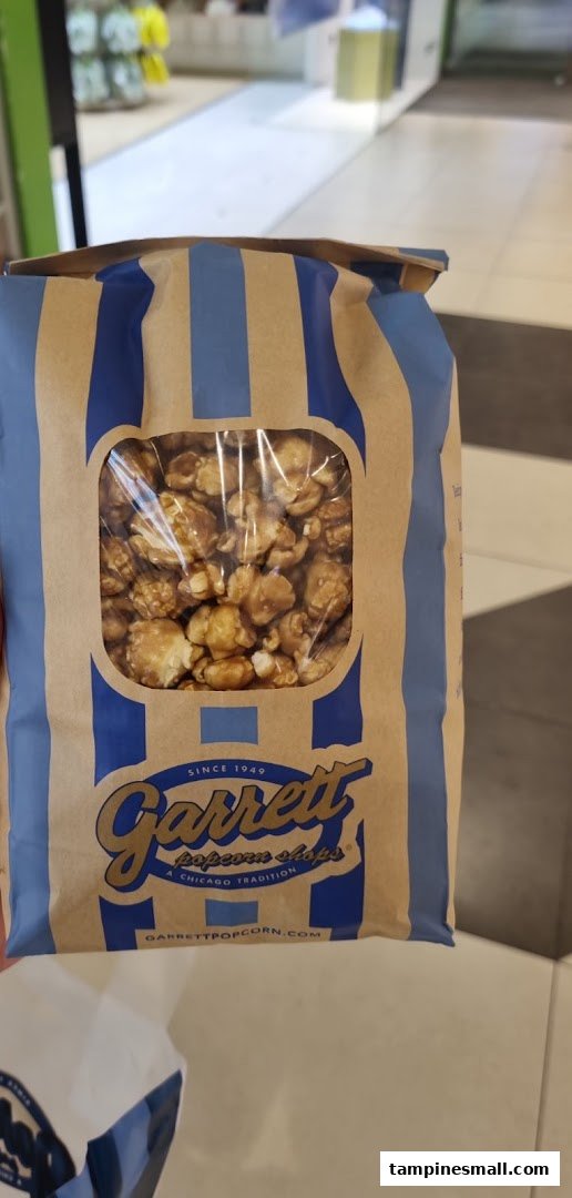 A close-up of a classic Garrett Popcorn Shops bag filled with delicious caramel popcorn.