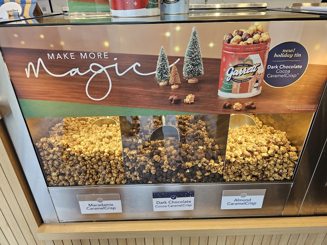 A vibrant display of Garrett Popcorn flavors, including holiday specials, showcased in a retail setting.