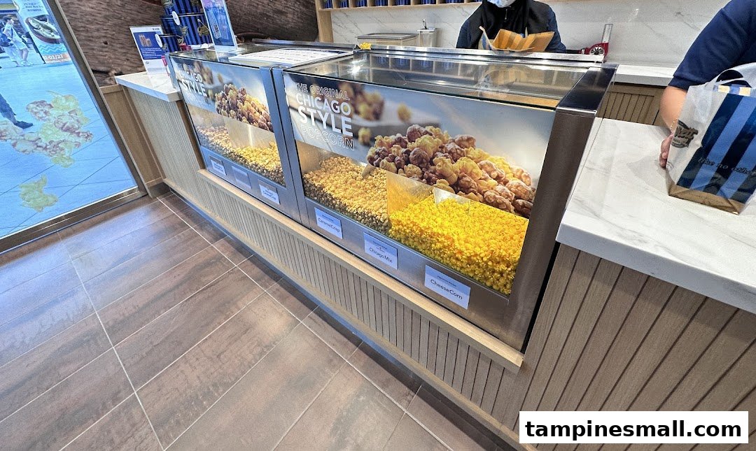 A counter at Garrett Popcorn Shops displaying various popcorn flavors like Chicago Mix and CheeseCorn.