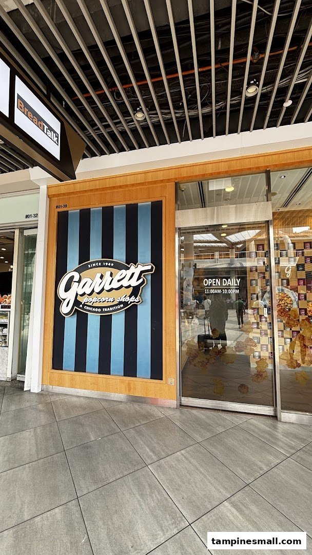 The storefront of Garrett Popcorn Shops featuring its classic striped logo and entrance with operating hours.