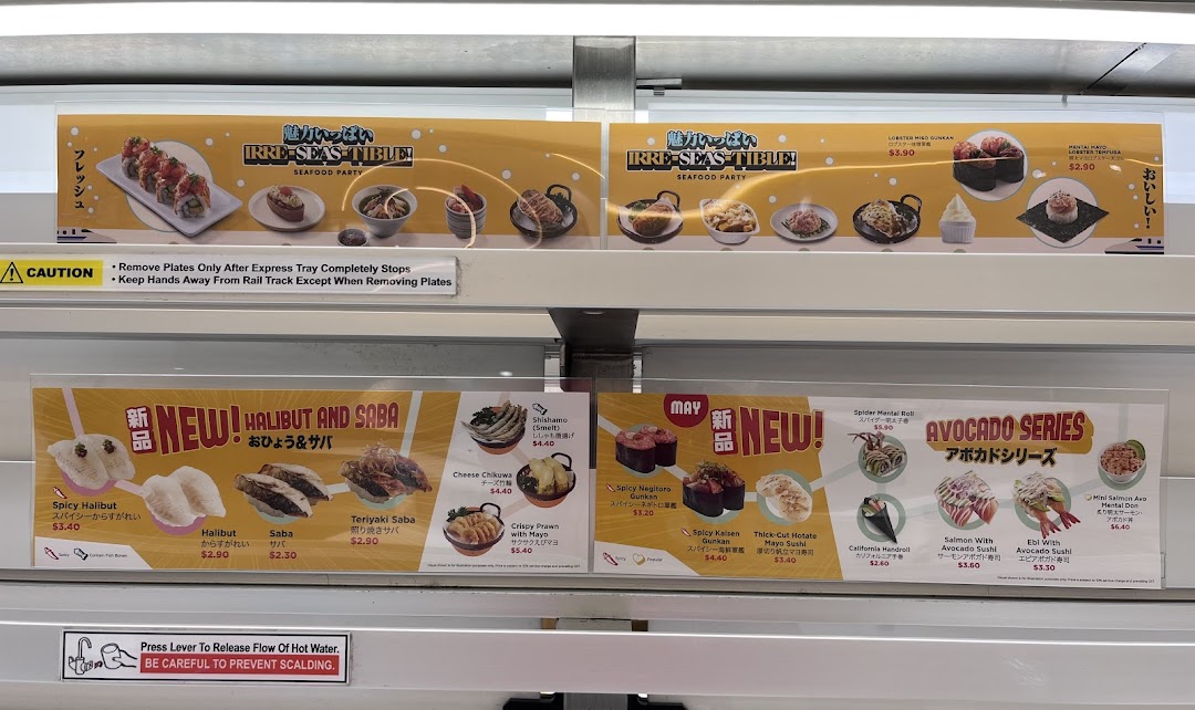 A vibrant display of sushi and Japanese dishes, showcasing new and seasonal menu items on a conveyor belt system.