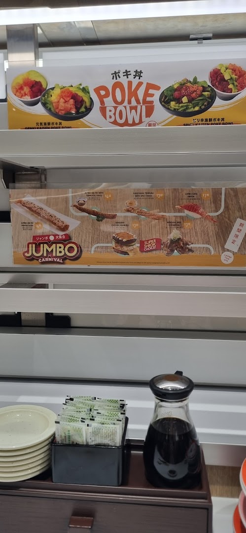Promotional displays for poke bowls and Jumbo Carnival items above a dining counter with condiments.