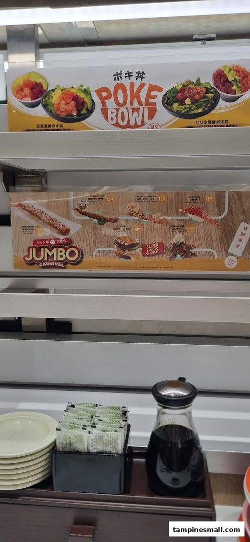 Promotional displays for poke bowls and Jumbo Carnival items above a dining counter with condiments.