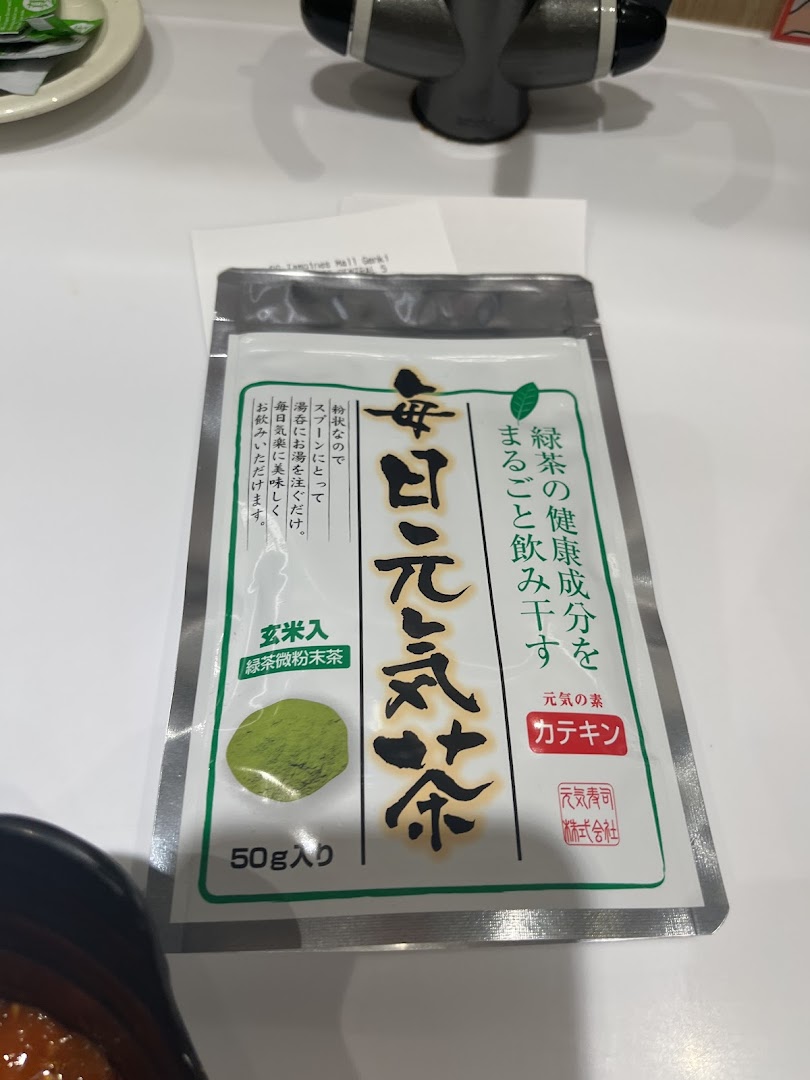 A packet of Genki Tea (green tea powder) on a table inside Genki Sushi.