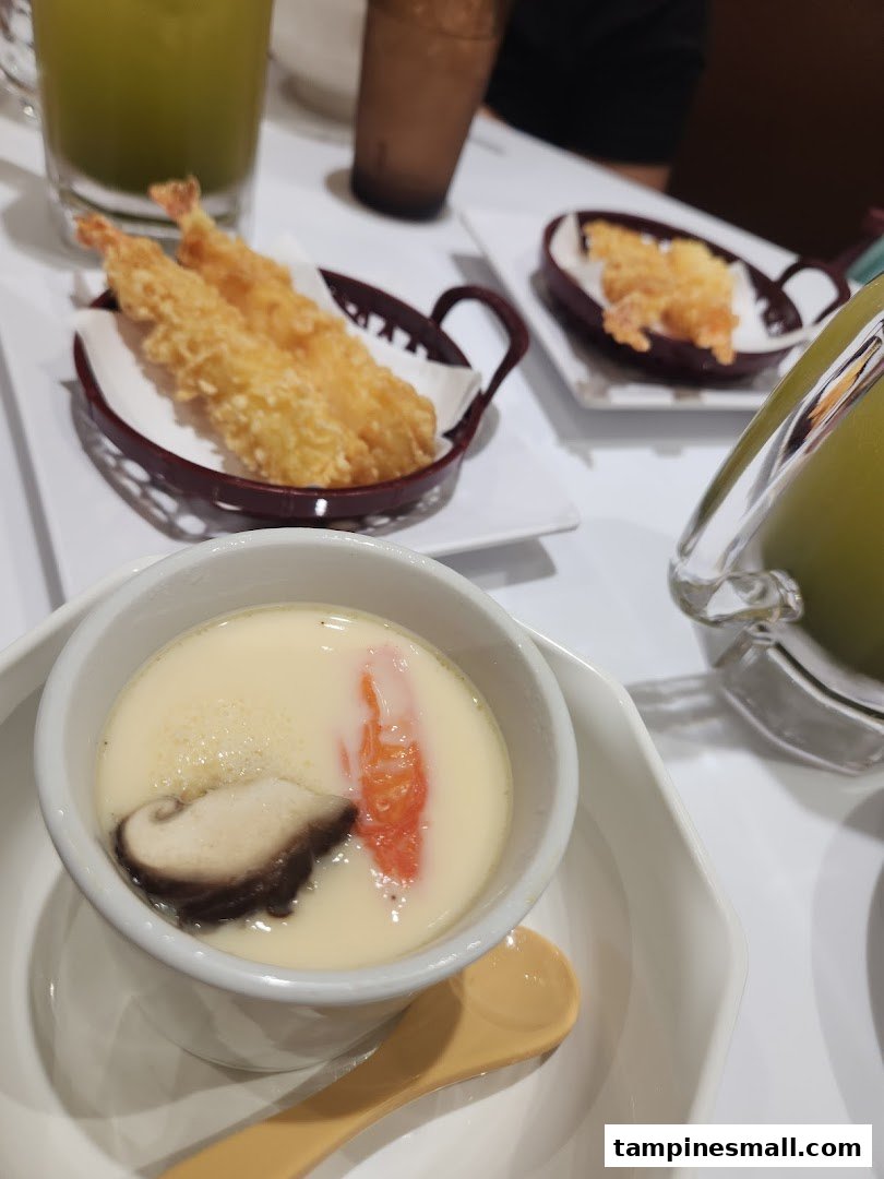 A close-up of chawanmushi and tempura shrimp served on a table at Genki Sushi.