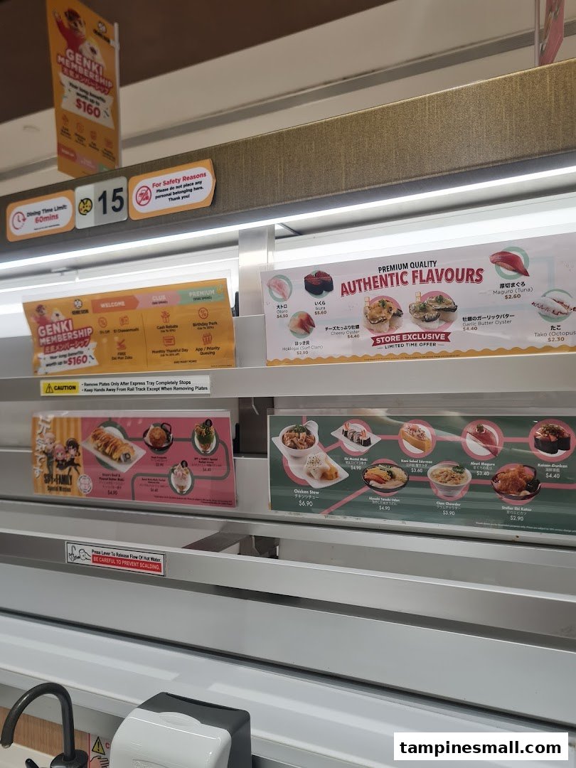 Conveyor belt sushi restaurant interior with various dishes, promotions, and safety signs.
