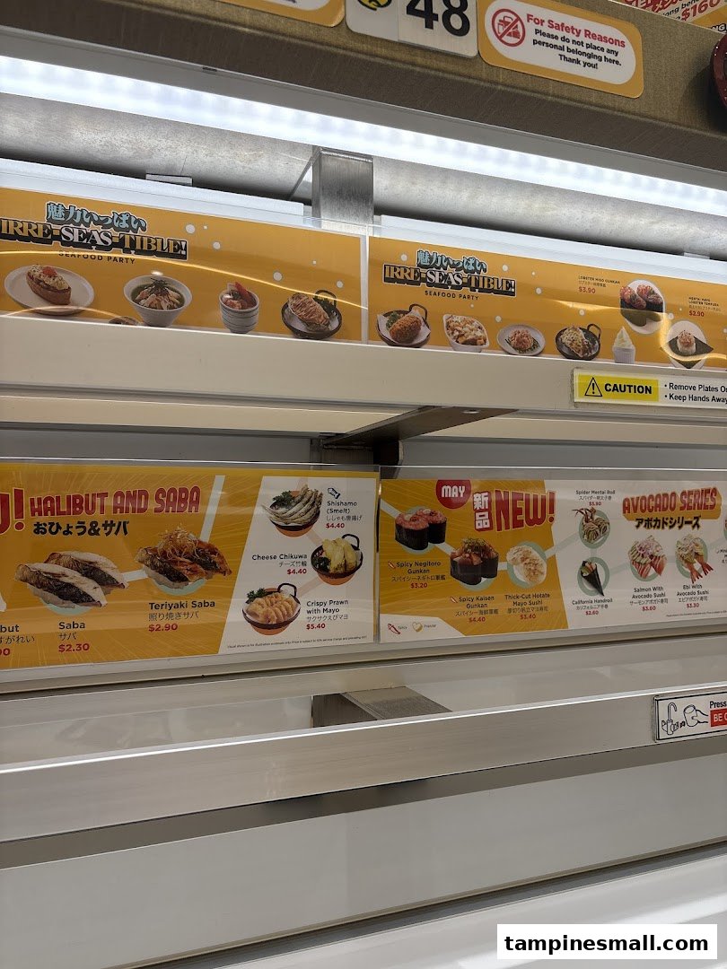 Close-up of Genki Sushi's conveyor belt menu displays featuring various sushi and seafood dishes.