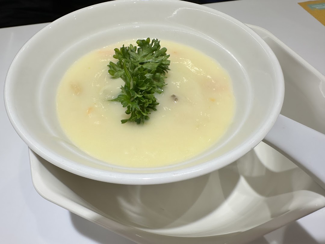 A creamy soup garnished with fresh parsley, served in a white bowl.