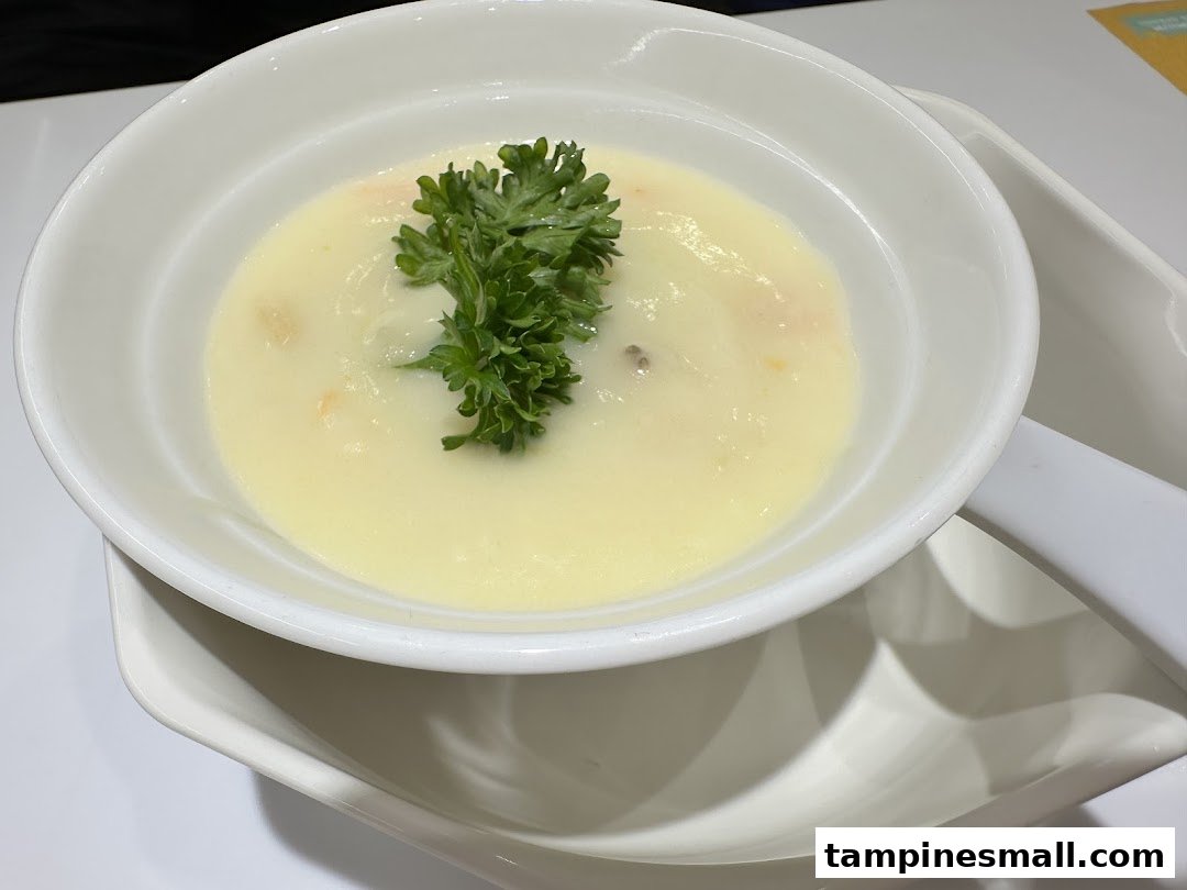 A creamy soup garnished with fresh parsley, served in a white bowl.