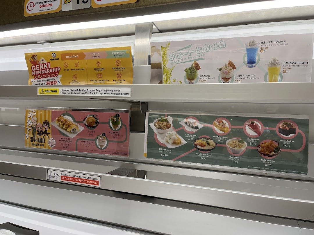 Close-up of Genki Sushi's conveyor belt displaying menu items, desserts, drinks, and membership benefits.