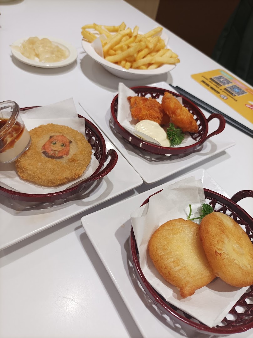 A table laden with various fried food items, including fries, croquettes, and fried fish/chicken.