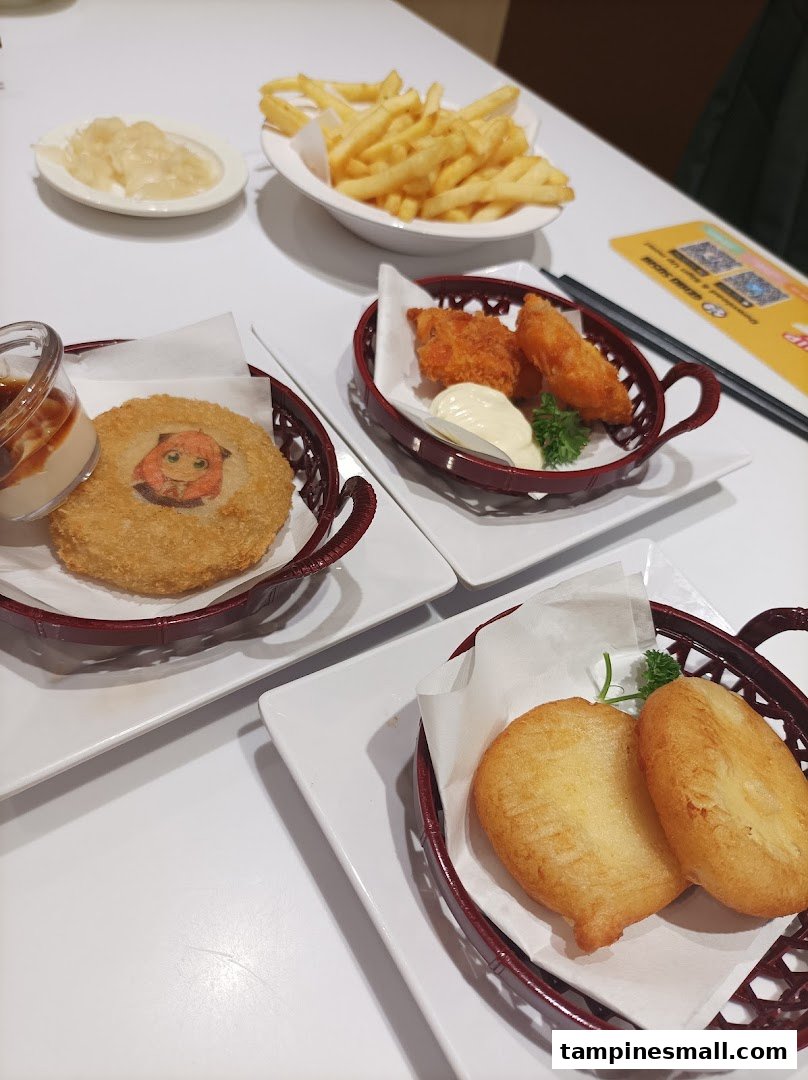 A table laden with various fried food items, including fries, croquettes, and fried fish/chicken.