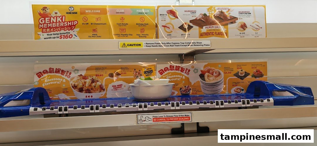A close-up of Genki Sushi's express train delivery system with various menu items and membership benefits displayed.
