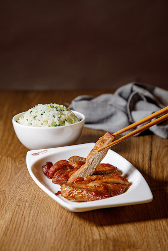 A delicious plate of sliced pork chop with a side of fried rice, ready to be enjoyed.