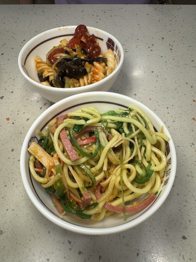 Two bowls of delicious pasta and noodle dishes, featuring fresh ingredients and vibrant colors.