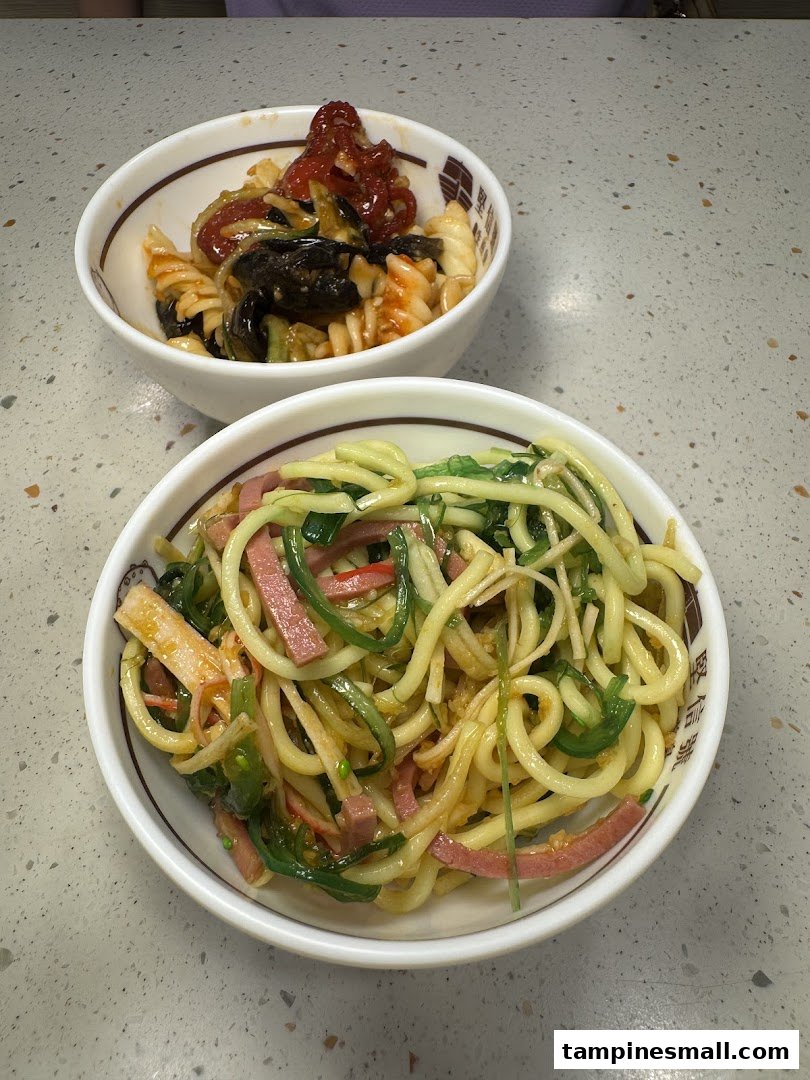 Two bowls of delicious pasta and noodle dishes, featuring fresh ingredients and vibrant colors.