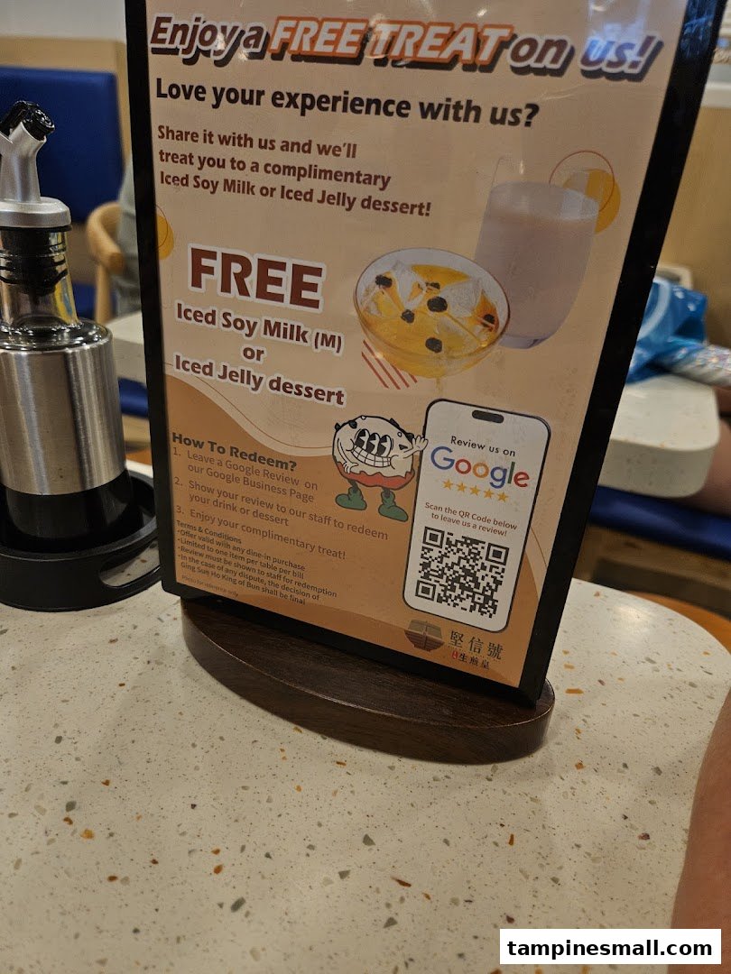 A table-top sign promoting a free iced soy milk or jelly dessert for a Google review.