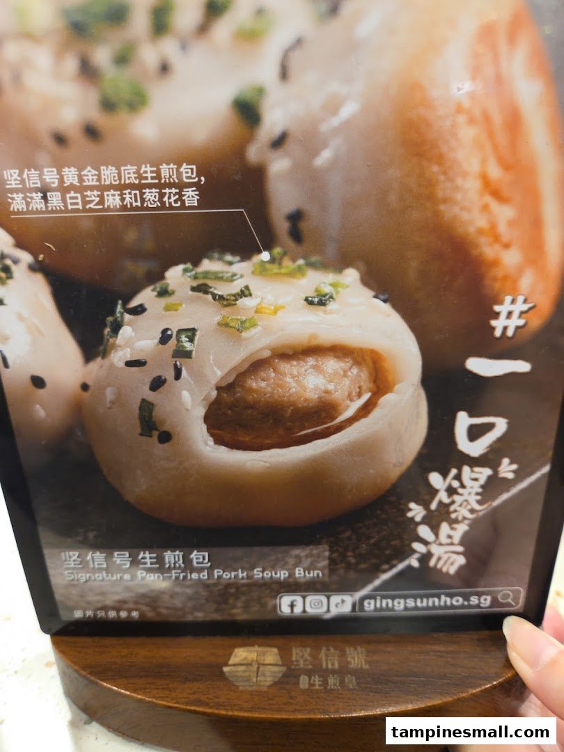 A close-up image of a Signature Pan-Fried Pork Soup Bun on a display stand.