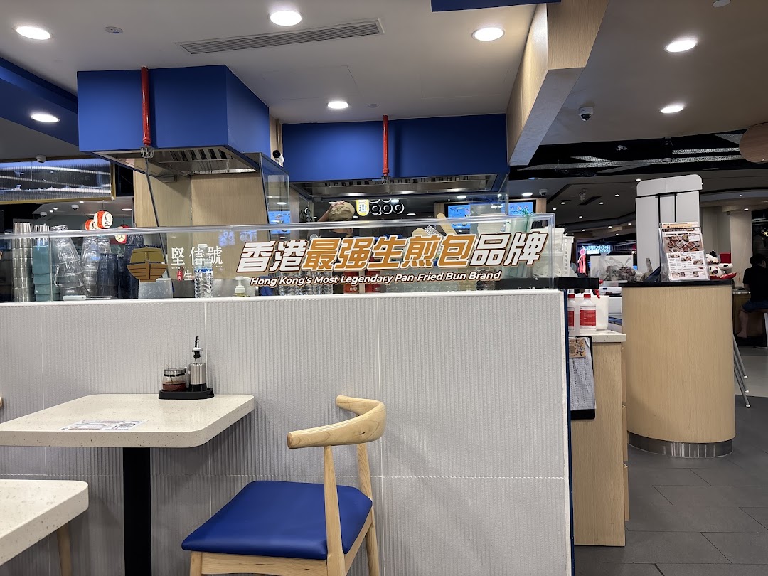 Interior view of Ging Sun Ho King of Bun, featuring seating and a sign promoting its legendary pan-fried buns.