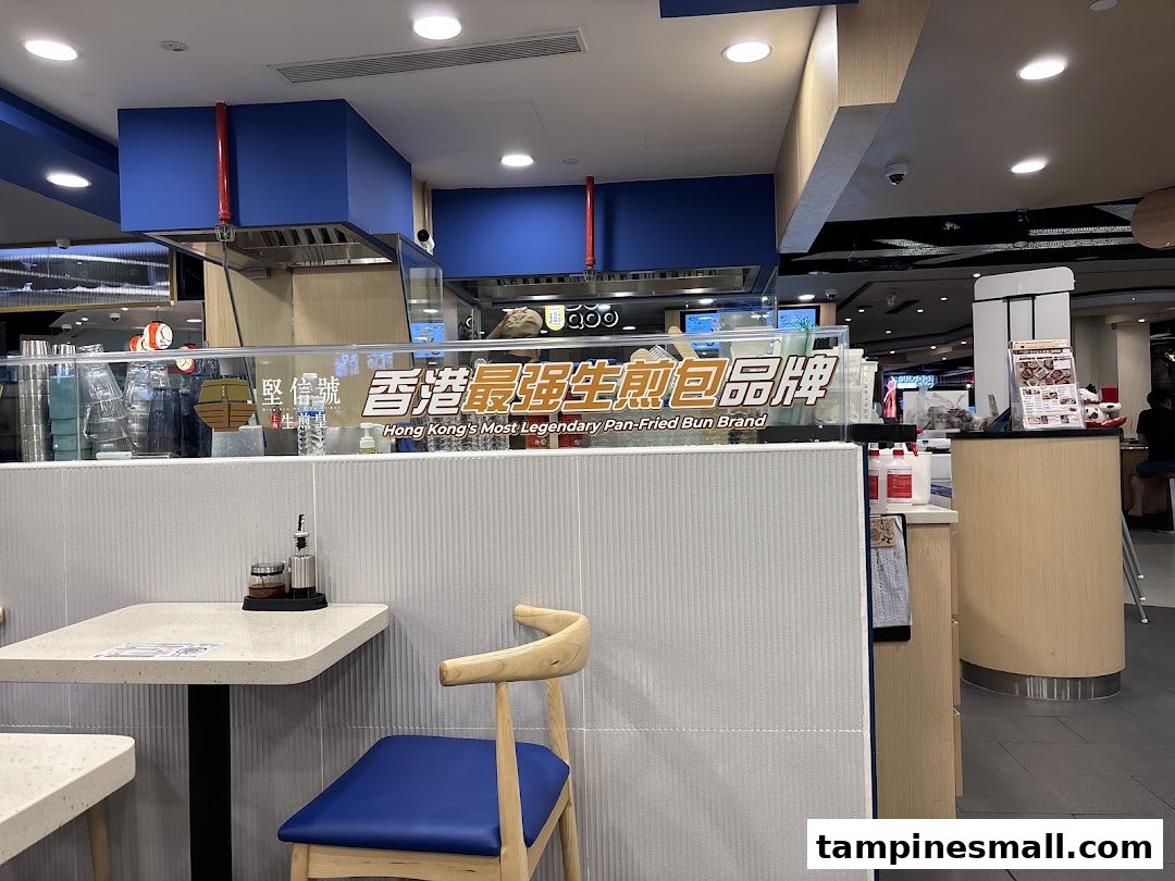 Interior view of Ging Sun Ho King of Bun, featuring seating and a sign promoting its legendary pan-fried buns.