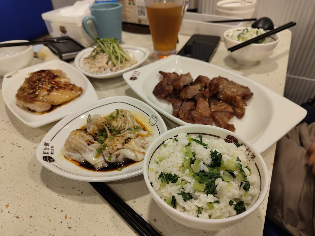 A table laden with delicious Chinese dishes including chicken, pork, dumplings, and rice.