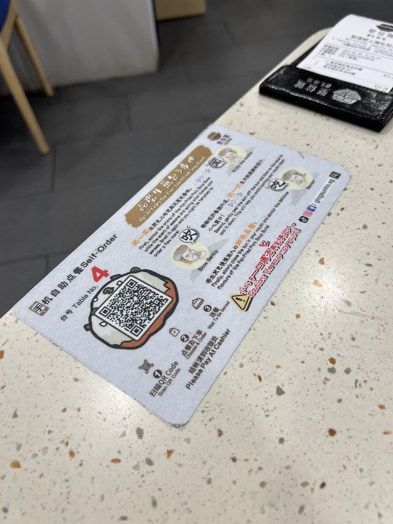 A self-order instruction card with a QR code and tips for enjoying a pan-fried pork soup bun.