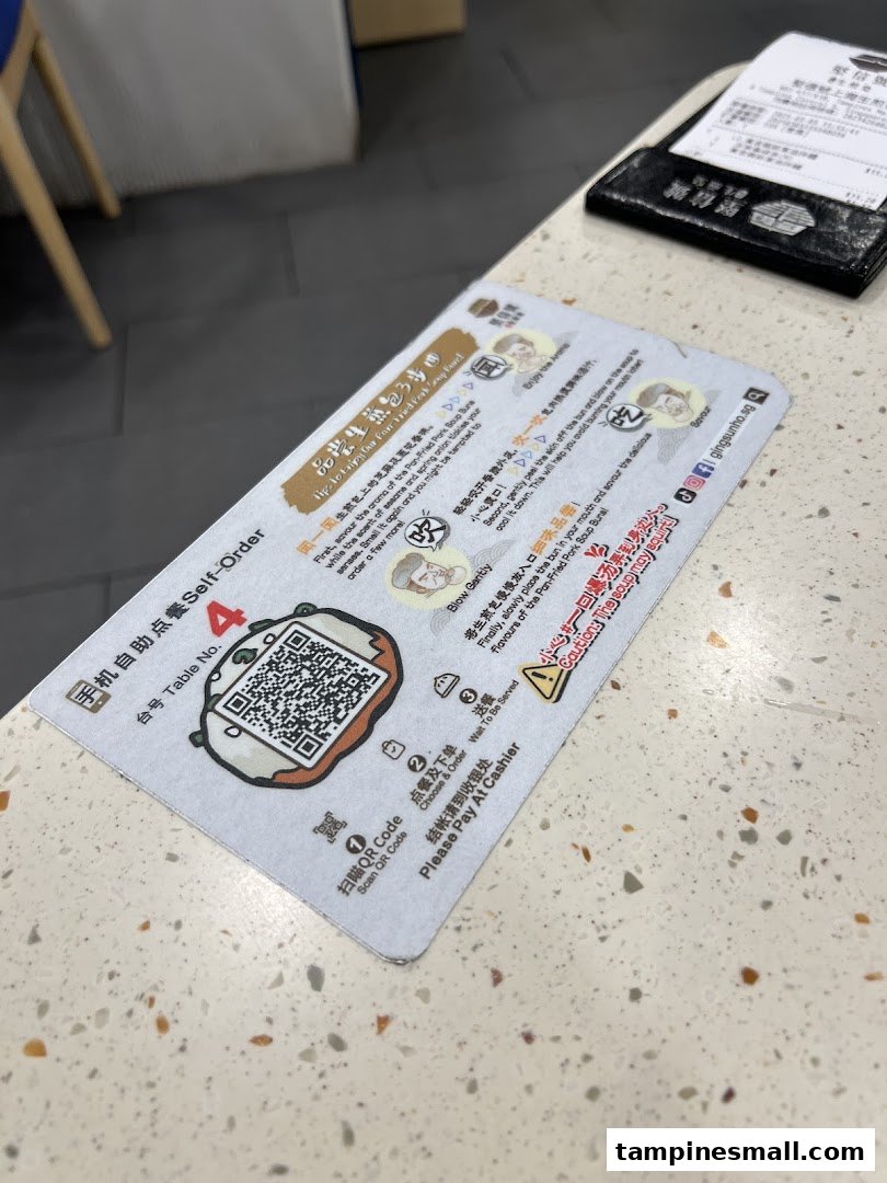 A self-order instruction card with a QR code and tips for enjoying a pan-fried pork soup bun.