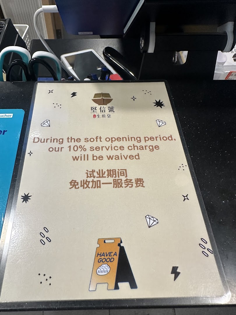 A sign at Ging Sun Ho King of Bun announcing a waived 10% service charge during soft opening.