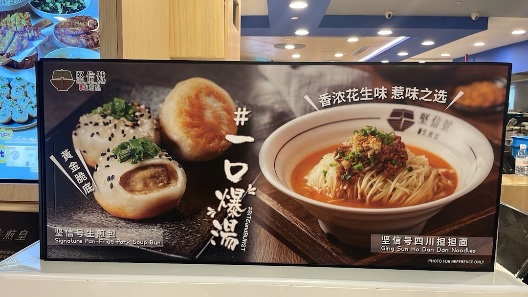 A promotional display board showcasing Signature Pan-Fried Pork Soup Buns and Dan Dan Noodles.