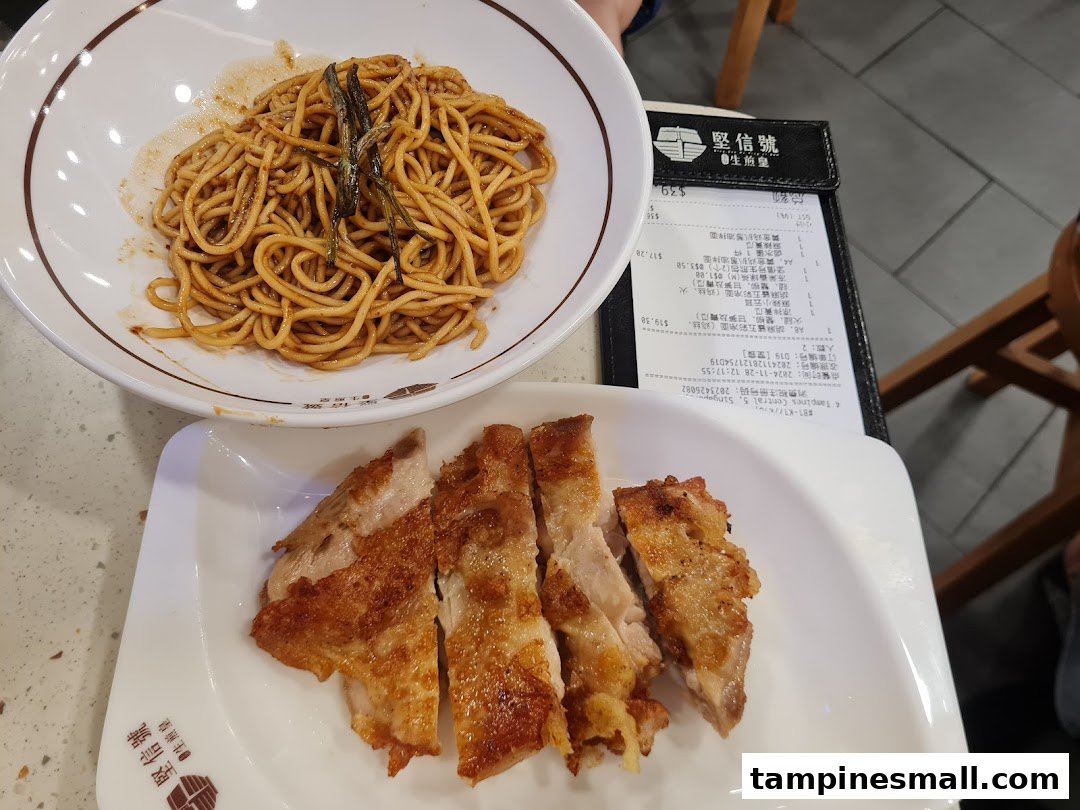 A delicious spread featuring golden chicken chop noodles and cold sesame noodles with a receipt.