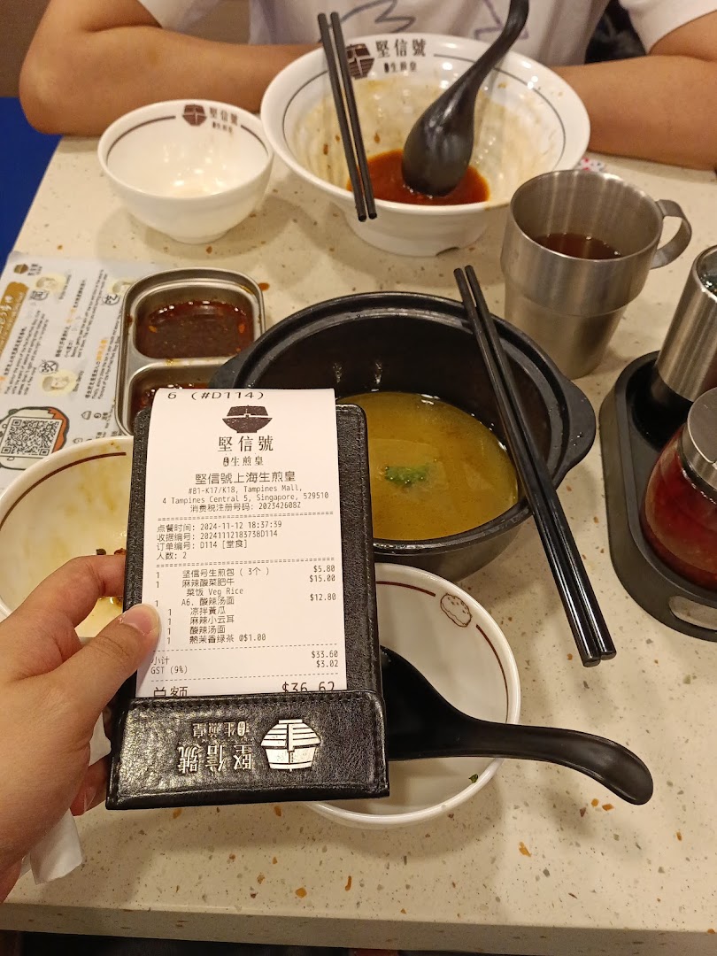 A dining table at Jian Xin Hao Sheng Jian Huang with partially eaten dishes and a customer's bill.