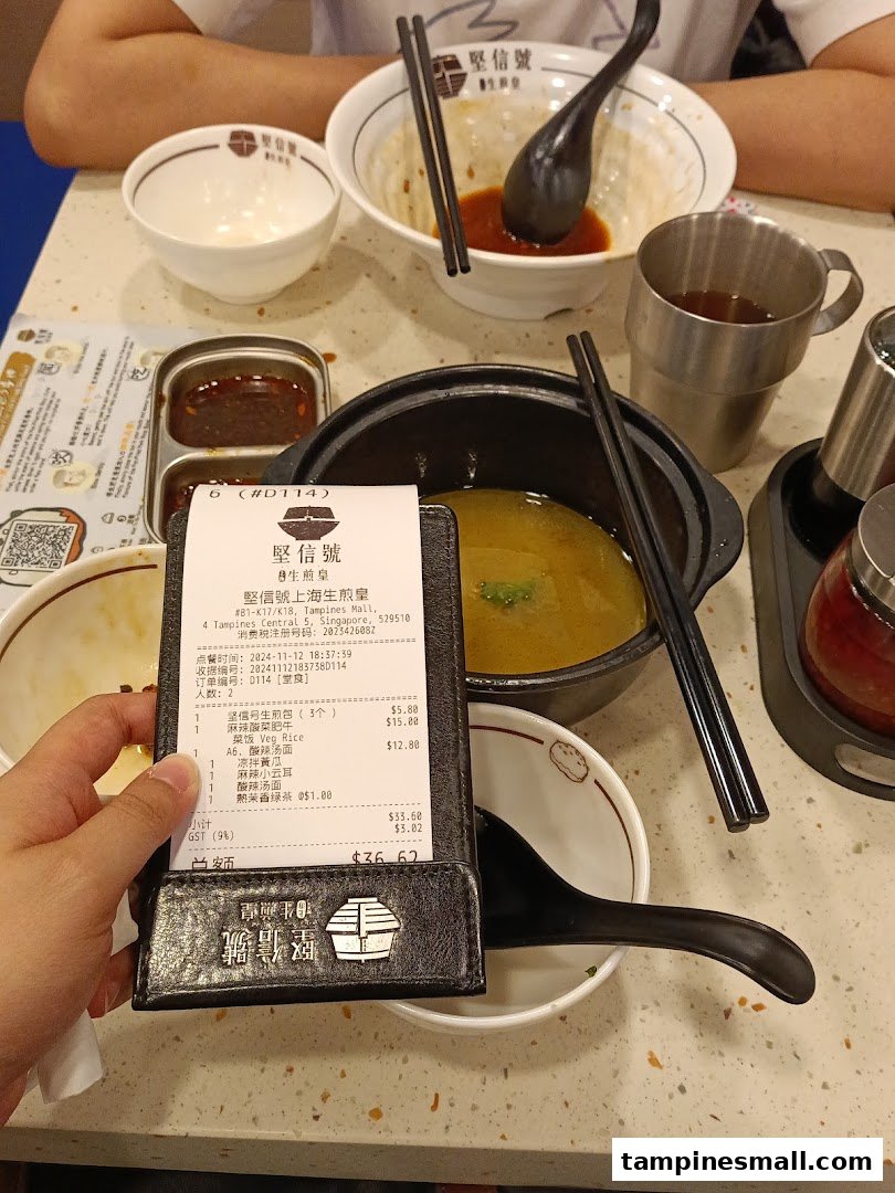 A dining table at Jian Xin Hao Sheng Jian Huang with partially eaten dishes and a customer's bill.