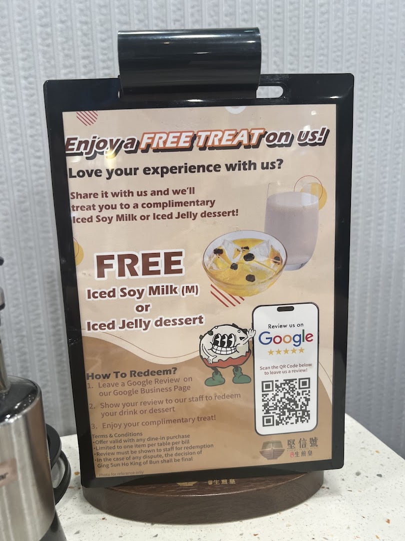 A sign promoting a free iced soy milk or jelly dessert for leaving a Google review.