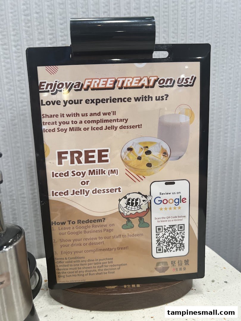 A sign promoting a free iced soy milk or jelly dessert for leaving a Google review.