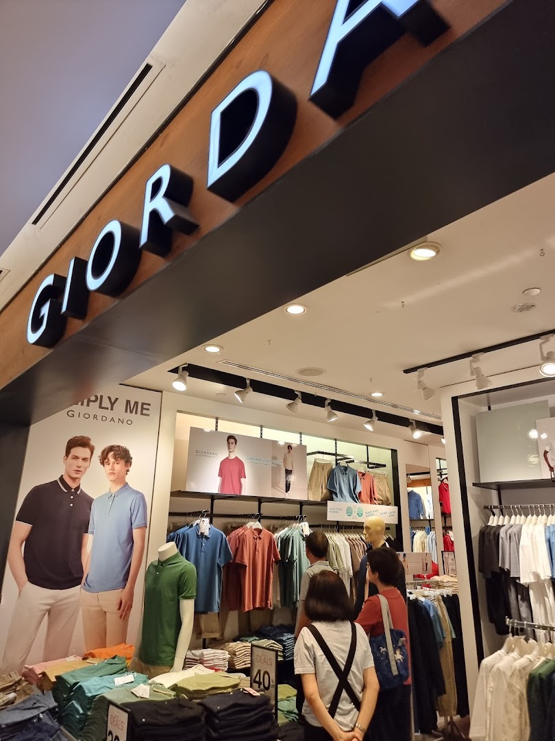 The Giordano shop entrance features its prominent logo, mannequins, and customers browsing a wide selection of apparel.