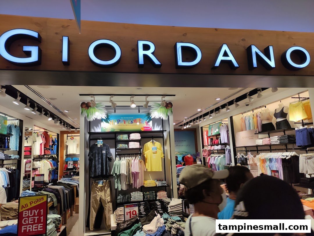 The brightly lit entrance of a Giordano clothing store, showcasing apparel and a 'Buy 1 Get 1 Free' offer.