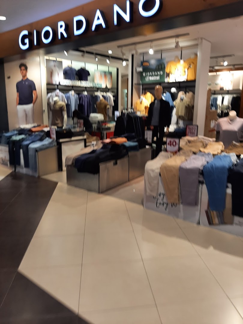 Interior view of Giordano clothing store showcasing casual wear on displays and mannequins.