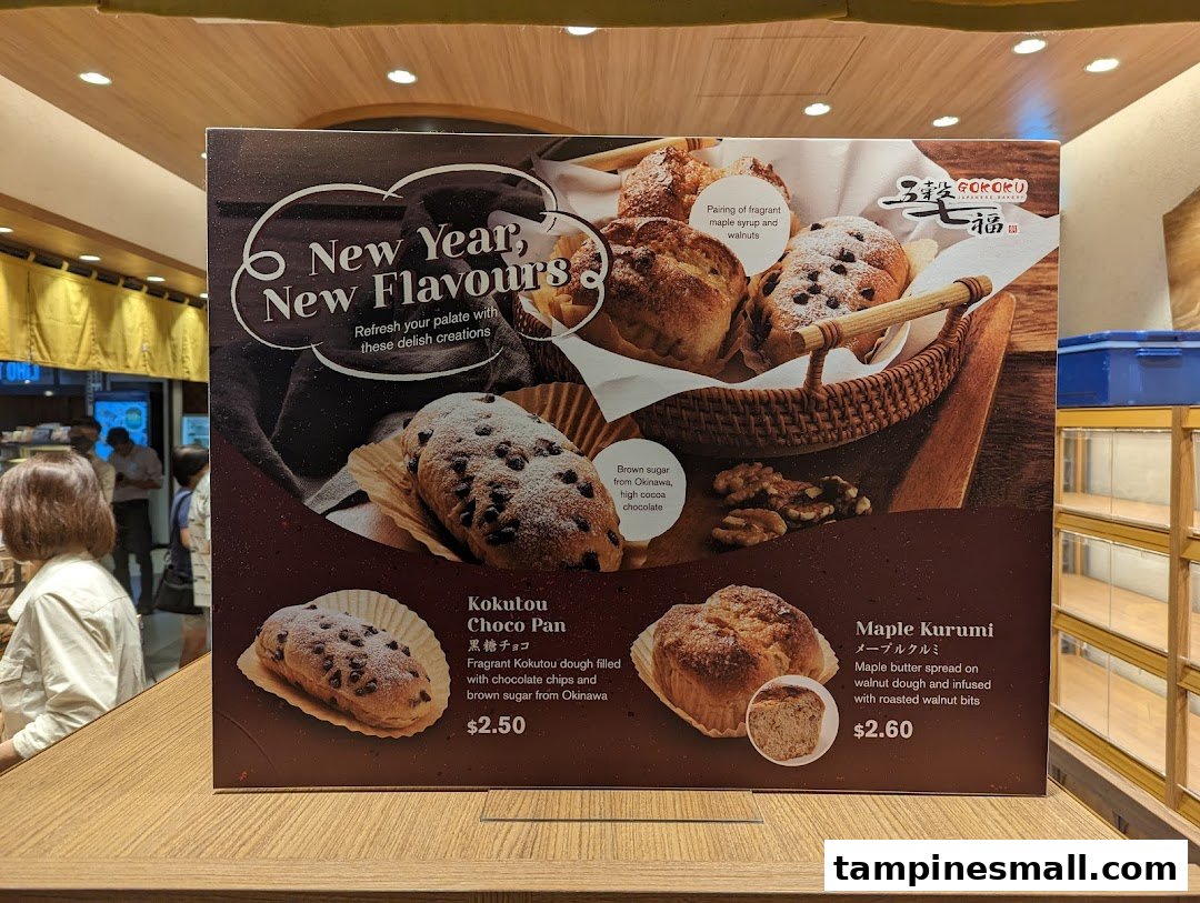 A promotional display board showcasing new bakery items with their descriptions and prices.