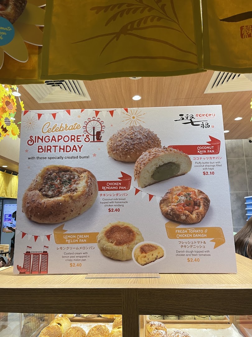 A promotional display board showcasing special buns for Singapore's Birthday at Gokoku Japanese Bakery.
