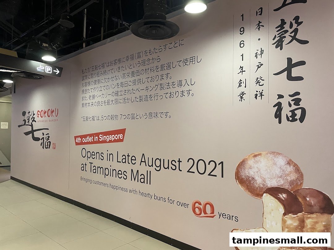 A large wall mural announcing the opening of Gokoku Japanese Bakery at Tampines Mall, featuring brand philosophy and bakery items.