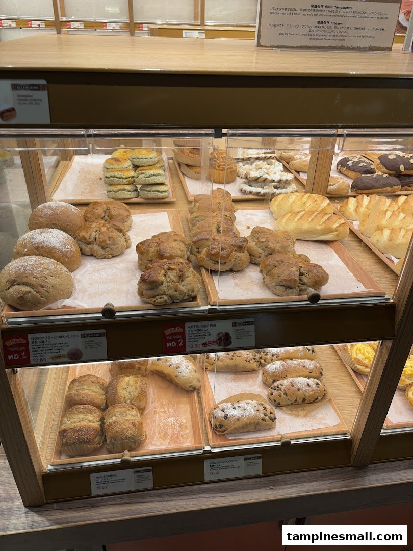 A vibrant display of freshly baked Japanese breads and pastries in a bakery showcase.