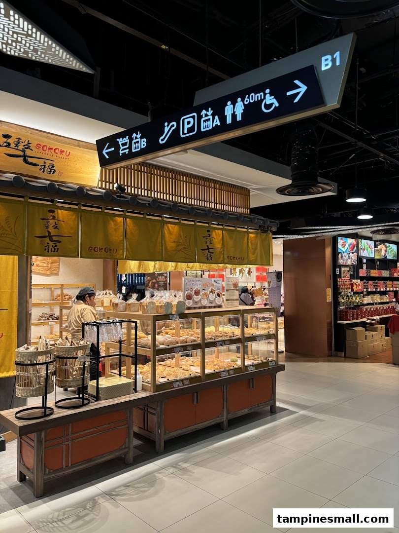 The inviting front of Gokoku Japanese Bakery, showcasing fresh bread displays and a staff member.