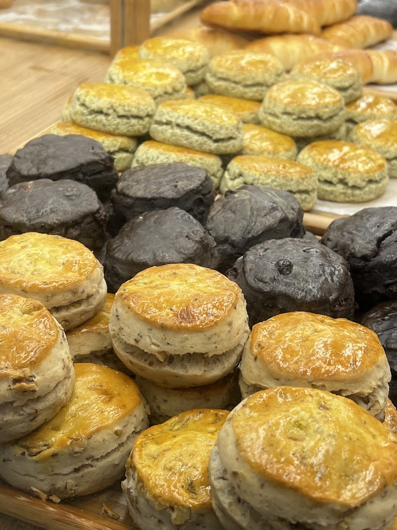 A close-up of various freshly baked scones, including plain and dark chocolate varieties, on display.