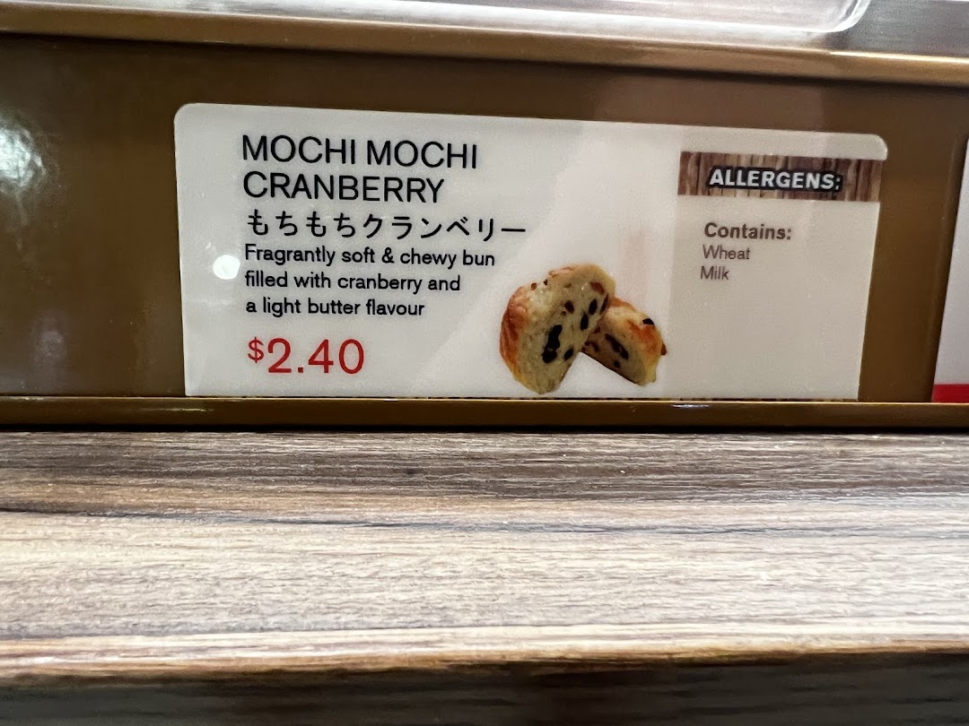 Close-up of a product label for Mochi Mochi Cranberry bun, showing description, price, and allergens.