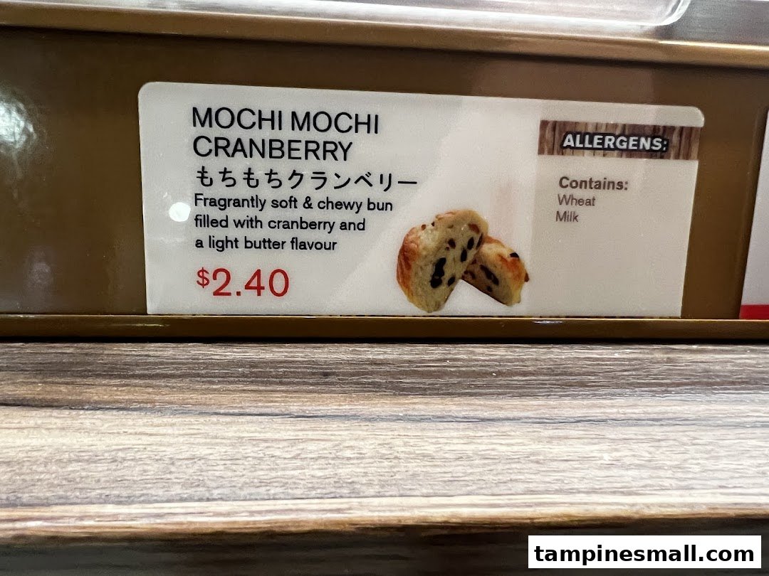 Close-up of a product label for Mochi Mochi Cranberry bun, showing description, price, and allergens.