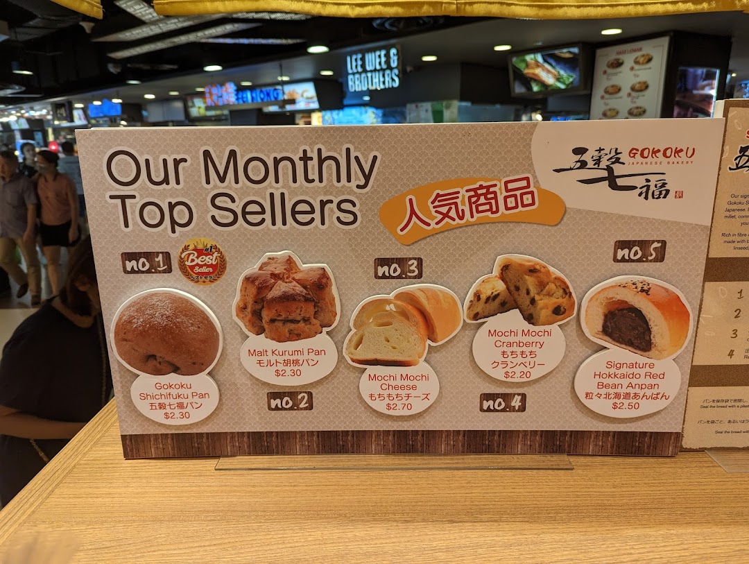 A display board showcasing Gokoku Japanese Bakery's monthly top-selling bread items with prices.